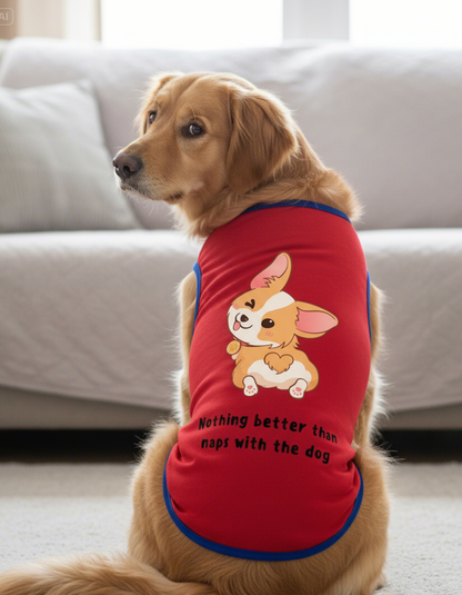 Dog wearing a red shirt with a cartoon dog and text, sitting on a couch.