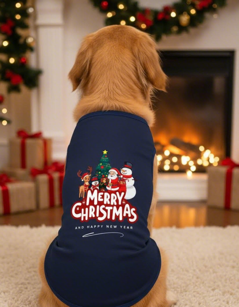 Dog wearing a Christmas-themed shirt in front of a fireplace with holiday decorations.